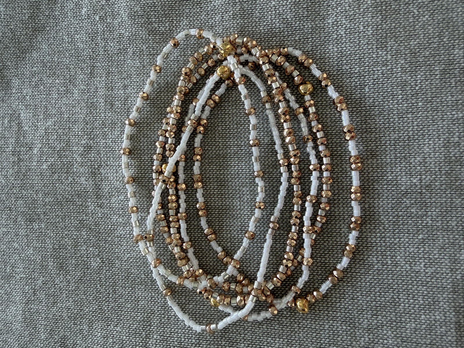 Gold and cream beaded bracelets in a soft pile