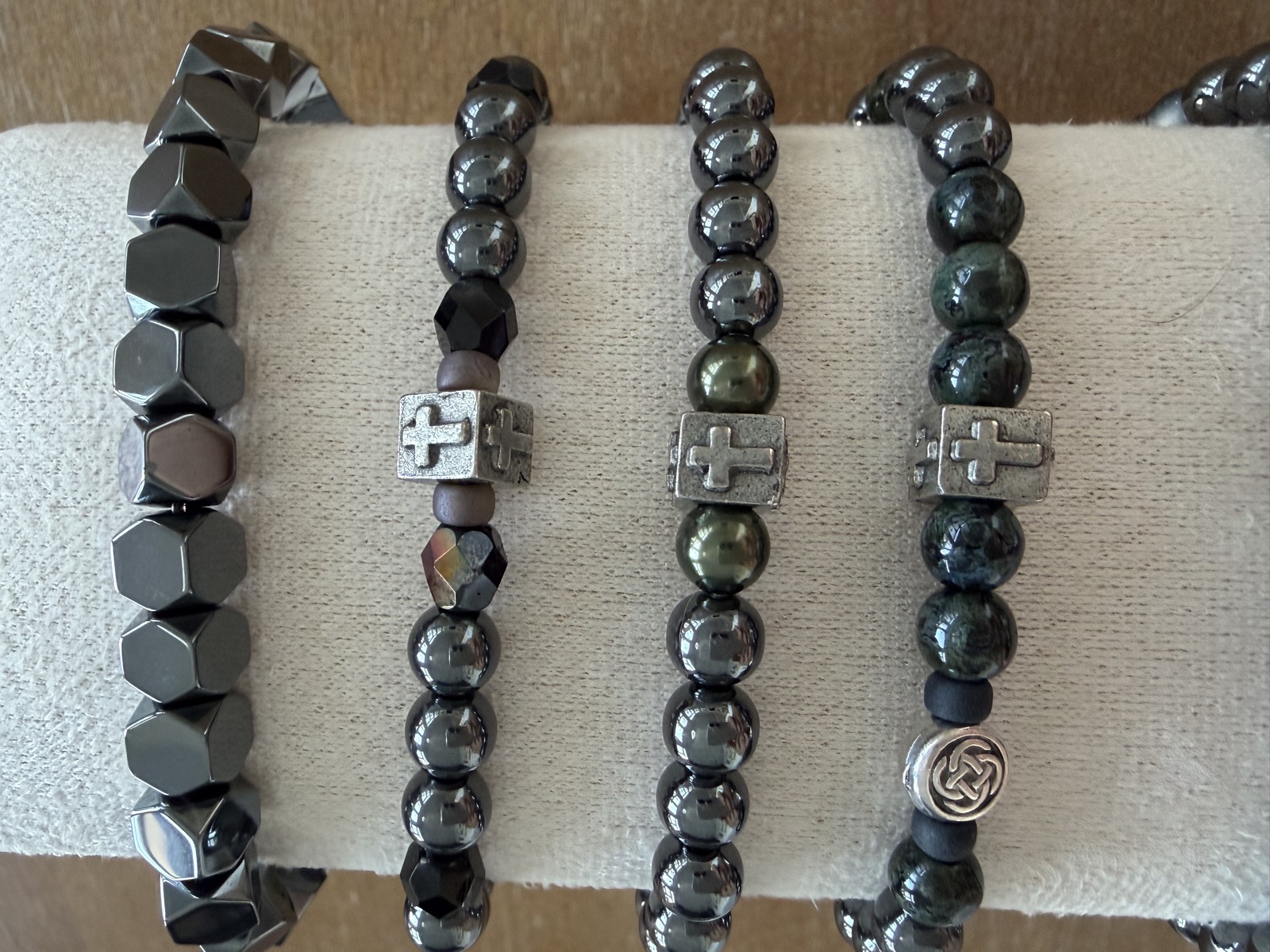 Row of dark men's bracelets with cross beads