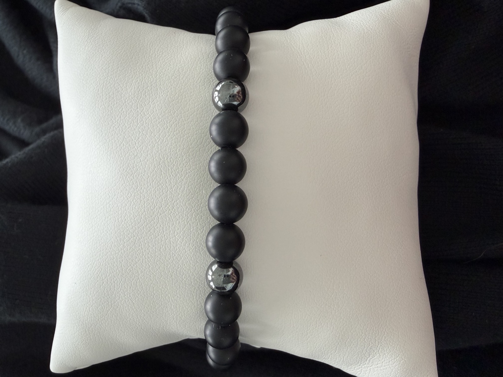 Matte onyx men's bracelet on a pillow